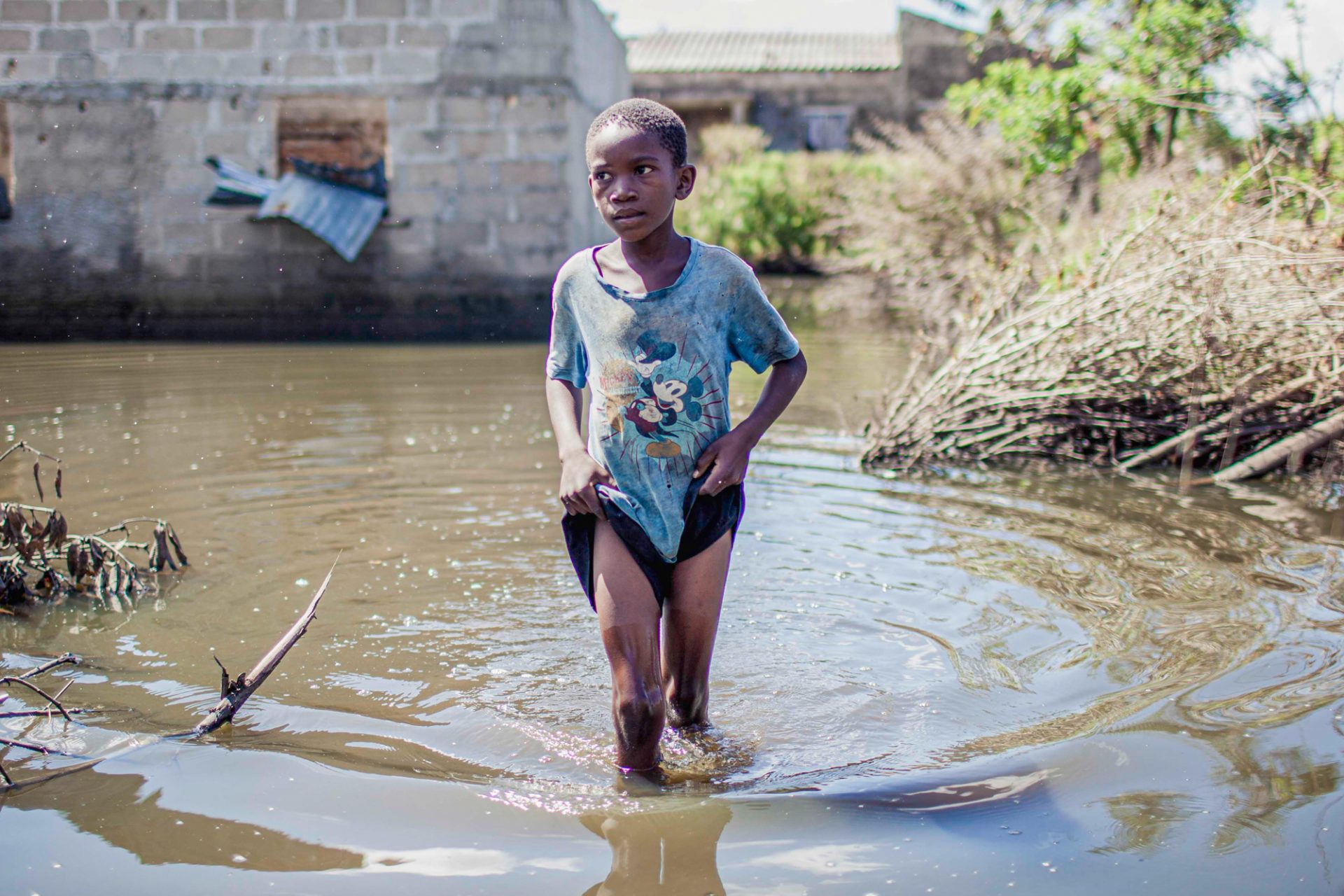 Dreng vader i vand til knæene i landsby