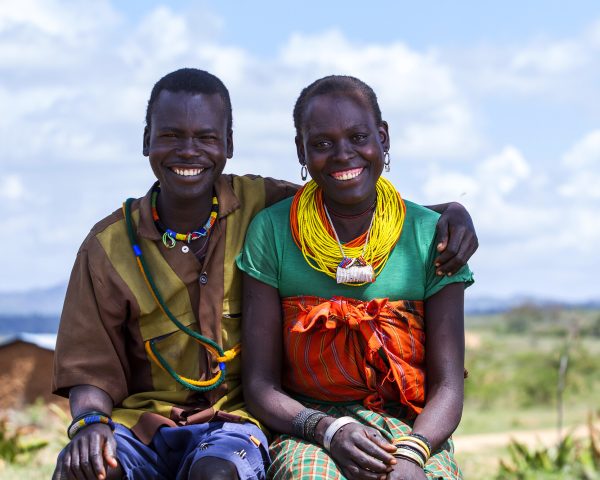 Mand sidder med armen om en kvinde og smiler, Uganda
