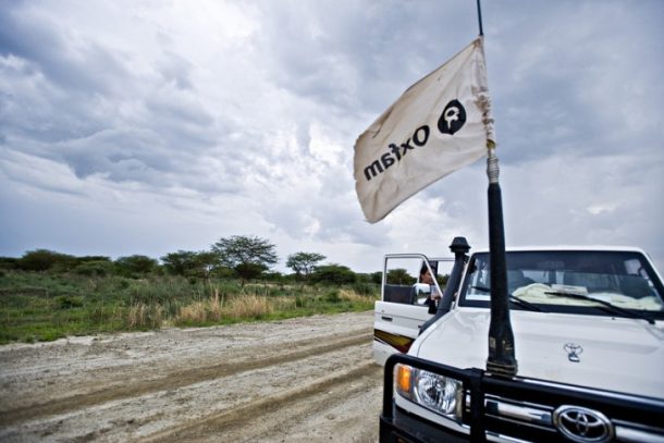 Bil på landevej med Oxfam-flag