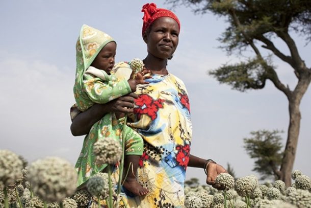 Etiopisk kvinde med sit barn på hoften