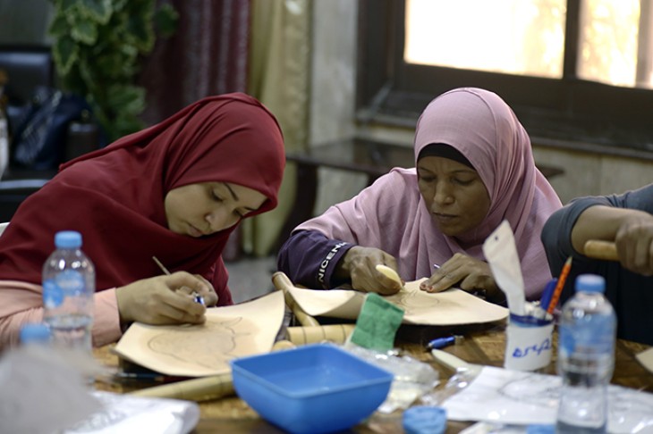 To kvinder fra Aswan kooperativet i Egypten tegner ved bord