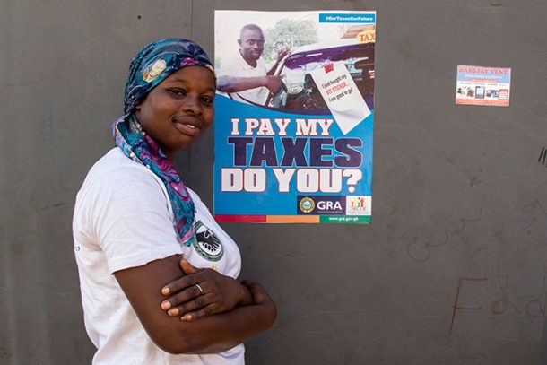 Kvinde foran plakat, Ghana