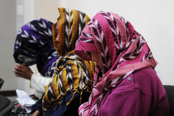 Tre kvinder med ansigterne dækked af mønstrede tørklæder