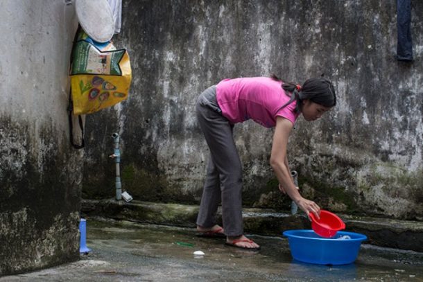 Kvinde foroverbøjet ved vaskebalje