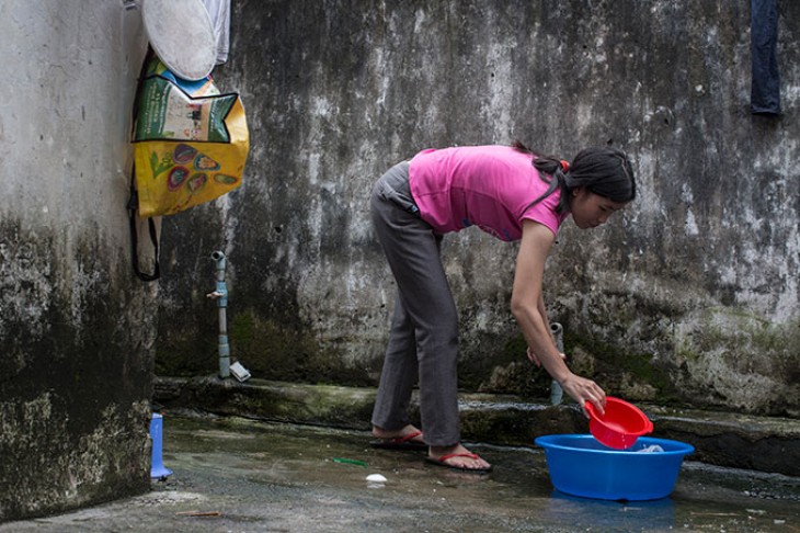 Kvinde foroverbøjet ved vaskebalje