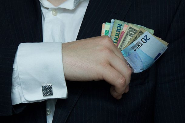 Skattely: Hånd med pengesedler i varierende valuta