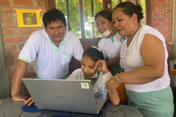 Kvinde, børn og mand ved laptop