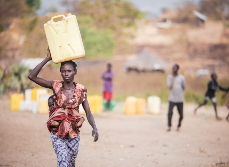 Kvinde bærer vanddunk på hovedet