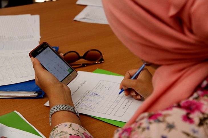 Kvinde med lommeregner og kuglepen udfylder skema på iværksætterkursus.